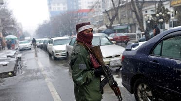 A Taliban fighter stands guard at a checkpoint during a snowfall in Kabul, Afghanistan, January 3, 2022. (Reuters)