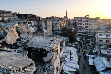 This aerial view shows Syrians buying food products at a market ahead of iftar, the evening meal that ends the daily fast at sunset, on the second day of the Islamic holy month of Ramadan, in the war-ravaged city of Ariha, located near the strategic M4 highway, in the southern countryside of the Idlib province, on April 15, 2021. (AFP)
