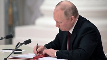 Russian President Vladimir Putin signs documents, including a decree recognizing two Russian-backed breakaway regions in eastern Ukraine as independent entities, Feb. 21, 2022. (Reuters)