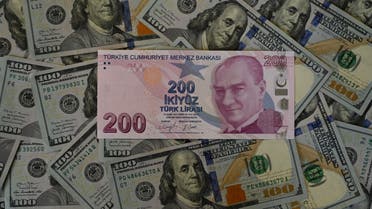 A picture taken on December 7, 2021 in Istanbul shows US dollars banknotes and Turkish lira banknotes. (AFP)