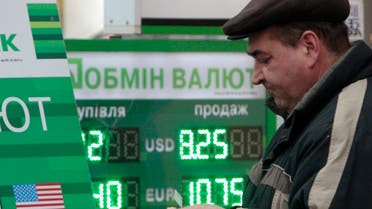 A man counts money near a currency exchange office in Kyiv on November 14, 2012. (Reuters)