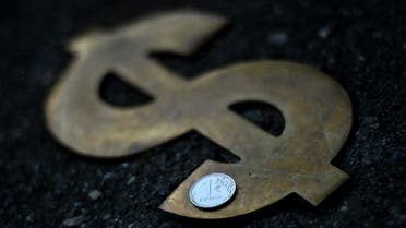 A Russian ruble coin is pictured on US dollar sign in Moscow on August 13, 2021. (AFP)