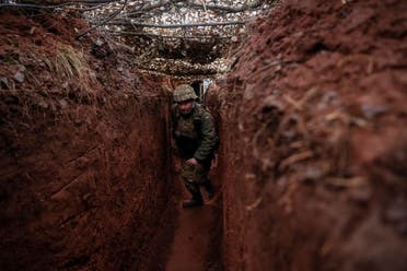 A Ukrainian service member walks along a trench at a position on the front line near the city of Novoluhanske in the Donetsk region, Ukraine February 22, 2022. (Reuters)