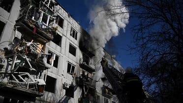 Firefighters work on a fire on a building after bombings on the eastern Ukraine town of Chuguiv on February 24, 2022, as Russian armed forces are trying to invade Ukraine from several directions, using rocket systems and helicopters to attack Ukrainian position in the south, the border guard service said. (AFP)