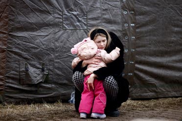 لاجئة أوكرانية مع طفلتها في مخيم ببولندا - رويترز