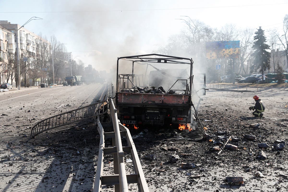 A Ukranian fireman kneels by a damaged vehicle, at the site of a fighting with Russian troops after Russia launched a massive military operation against Ukraine, in Kyiv, Ukraine, on February 26, 2022. (Reuters)