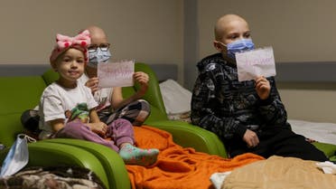 Children patients whose treatments are underway hold papers with the words “no war” written in them, at the hallways of the basement floor of Okhmadet Children’s Hospital, as Russia’s invasion of Ukraine continues, in Kyiv, Ukraine, on February 28, 2022. (Reuters)