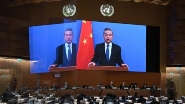 Chinese Foreign minister Wang Yi appears on a screen as he delivers a remote speech at the opening of a session of the UN Human Rights Council, following the Russian invasion in Ukraine, in Geneva, on February 28, 2022. (AFP)