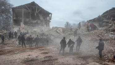People remove debris at the site of a military base building that, according to the Ukrainian ground forces, was destroyed by an air strike, in the town of Okhtyrka in the Sumy region, Ukraine, on February 28, 2022. (Reuters)