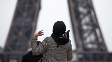 A woman wearing a hijab walks at Trocadero square near the Eiffel Tower in Paris, France, May 2, 2021. (Reuters)