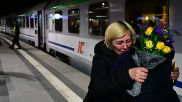 A woman is comforted by a friend after arriving on a train from Ukraine’s border at Berlin’s main train station on March 2, 2022. (Photo by Tobias SCHWARZ / AFP)