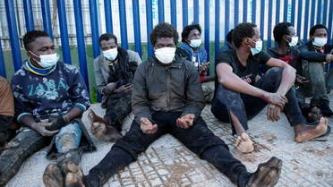 Migrants sit outside the temporary migrants center upon crossing the border fence at Spain's North African enclave of Melilla, Spain January 19, 2021. (File photo: Reuters)