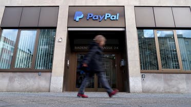 A pedestrian walks past the PayPal logo at an office building in Berlin, Germany, March 5, 2019. (File Photo: Reuters)