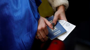 A Ukrainian national holds her passport during the arrival of Ukrainians fleeing the conflict in their country at the Paris-Beauvais Airport in Tille, north of Paris, on March 2, 2022, seven days after Russia launched a military invasion of Ukraine.