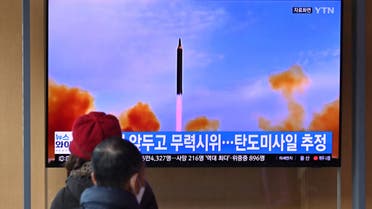 People watch a television screen showing a news broadcast with file footage of a North Korean missile test, at a railway station in Seoul on March 5, 2022, after North Korea fired at least one unidentified projectile in the country's ninth suspected weapons test this year according to the South's military. (Photo by Jung Yeon-je / AFP)