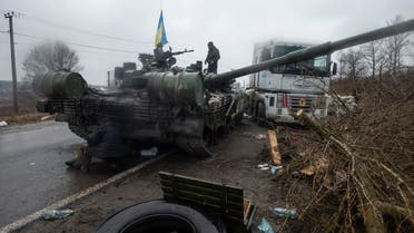 A Ukrainian serviceman stands at a captured Russian tank, amid the Russian invasion of Ukraine, in the north of the Kharkiv region, Ukraine March 2, 2022. (Reuters)