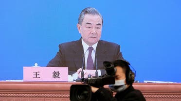 Chinese State Councilor and Foreign Minister Wang Yi is seen on a screen as he attends a news conference via video link on the sidelines of the National People's Congress (NPC), in Beijing, China March 7, 2022. (Reuters)