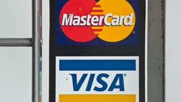 In this file photo taken on March 30, 2012, Visa and MasterCard credit card logos are seen in a store window in Washington, DC. (AFP)