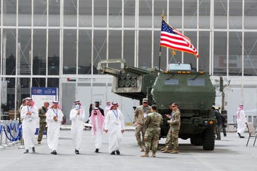 Saudi men are seen walking near a U.S. Army defence system on display at World Defense Show in Riyadh, Saudi Arabia, March 6, 2022. (Reuters)