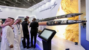People talk at the Lockheed Martin stand at World Defense Show in Riyadh, Saudi Arabia, March 7, 2022. (Reuters)