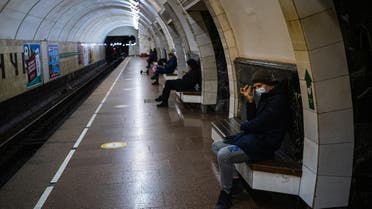 TOPSHOT - People sit in a underground metro station used as a bomb shelter in Kyiv on March 8, 2022. Ukraine's President Volodymyr Zelensky, invoking the wartime defiance of British prime minister Winston Churchill, vows to fight to the end in a historic virtual speech to UK lawmakers. (Photo by Dimitar DILKOFF / STF / AFP)