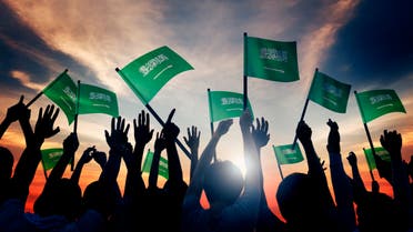 Silhouettes of People Holding Flag of Saudi Arabia stock photo