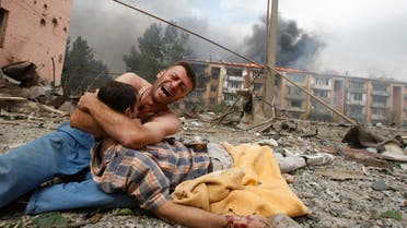 A Georgian man cries as he holds the body of his relative after a bombardment in Gori, 80 km (50 miles) from Tbilisi, August 9, 2008. A Russian warplane dropped a bomb on an apartment block in Gori on Saturday, killing at least 5 people, a Reuters reporter said. The bomb hit the five-story building close to Georgia's embattled breakaway province of South Ossetia when Russian warplanes carried out a raid against military targets around the town. REUTERS/Gleb Garanich (GEORGIA) BEST QUALITY AVAILABLE