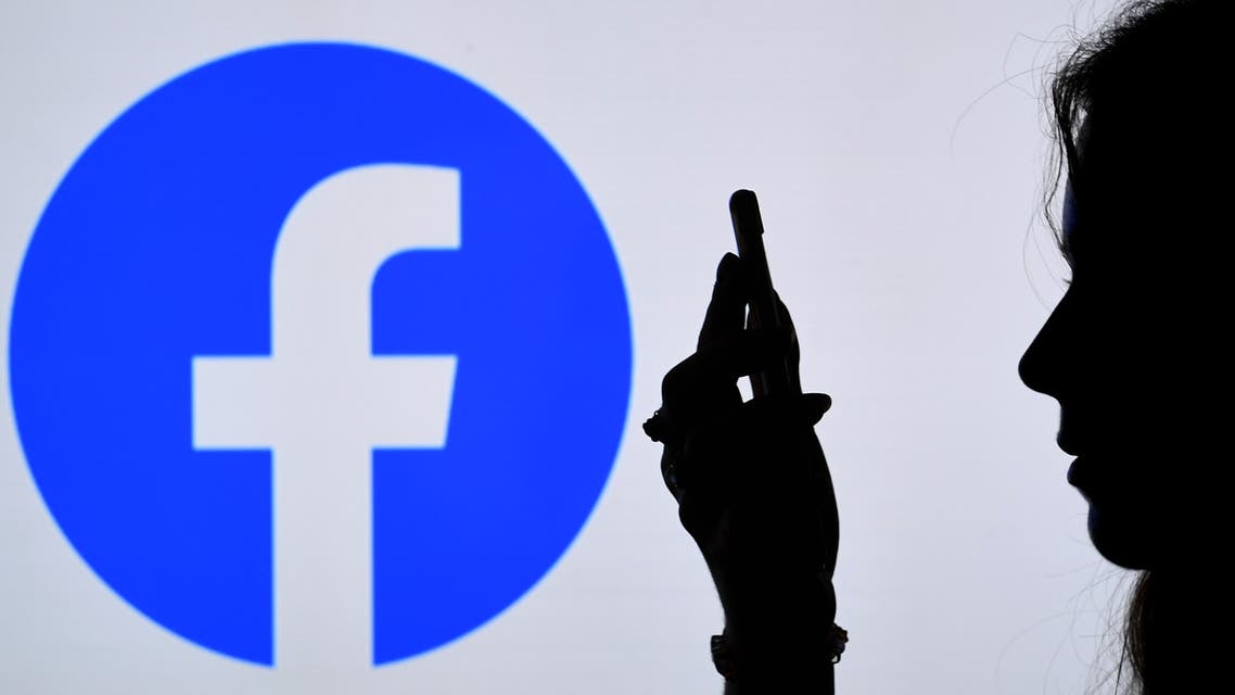 (FILES) In this file photo illustration, a person looks at a smart phone with a Facebook App logo displayed on the background, on August 17, 2021, in Arlington, Virginia. Facebook and multiple media websites were partially inaccessible in Russia on March 4, 2022, as authorities crack down on critical voices as fighting escalates in Ukraine. AFP journalists in Moscow were not able to access Facebook, as well as the sites of media outlets Meduza, Deutsche Welle, RFE-RL and the BBC's Russian-language service. The monitoring NGO GlobalCheck also said the sites were partially down.