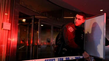 A member of the New York City Police Department (NYPD) ties police tape at the entrance of the Museum of Modern Art (MOMA) after an alleged multiple stabbing incident, in New York, US, March 12, 2022. (Reuters)