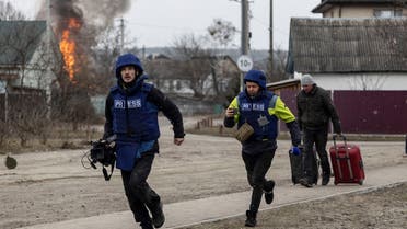 Journalists run for cover after heavy shelling on the only escape route used by locals, while Russian troops advance towards the capital, in Irpin, near Kyiv, Ukraine on March 6, 2022. (Reuters)
