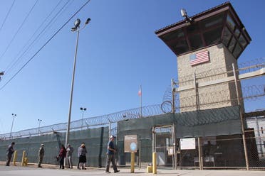 Poeple walk past a guard tower outside the fencing of Camp 5 at the US Military's Prison in Guantanamo Bay, Cuba on January 26, 2017.