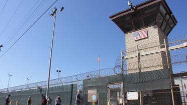 Poeple walk past a guard tower outside the fencing of Camp 5 at the US Military's Prison in Guantanamo Bay, Cuba on January 26, 2017. President Donald Trump has said he absolutely thinks torture works, but doctors, lawyers for terror suspects, and even fellow Republicans have pledged to oppose any effort to reinstate waterboarding or other banned interrogation techniques. (Photo by Thomas WATKINS / AFP)