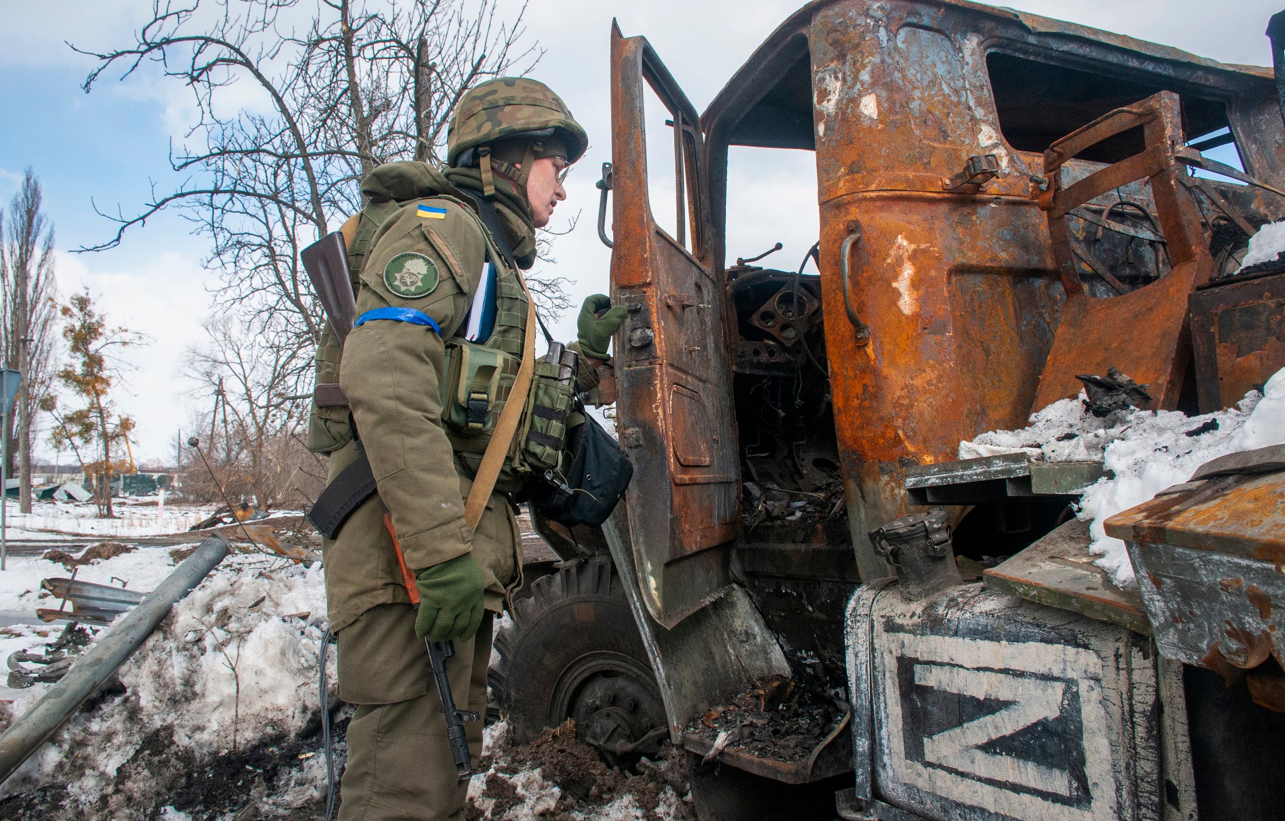 جندي أوكراني يعاين آلية عسكرية روسية مدمرة في خاركيف