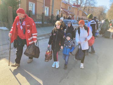 A Ukrainian Red Cross worker leads residents as they board busses  to leave the city as part of a safe passage out of Sumy, Ukraine. (Supplied)