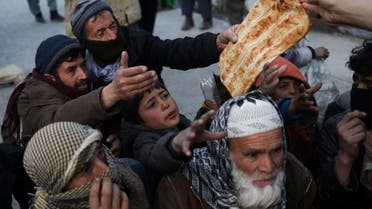 People reach out to receive bread, in Kabul, Afghanistan, January 31, 2022. (Reuters)