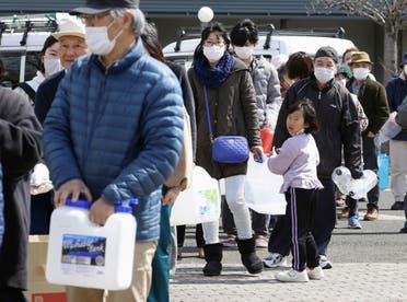 People wait in line to receive water following a strong earthquake in Kunimi, Fukushima Prefecture, Japan in this photo taken by Kyodo on March 17, 2022. (Reuters)