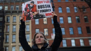 A demonstrator holds a sign outside a Citibank location during an anti-war rally, amid Russia's invasion of Ukraine, in New York City, US, on March 16, 2022. (Reuters)
