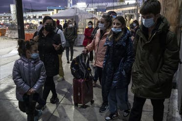 Ukrainian citizens walk along with an advocate (L) on the Mexican side of the border after being rejected from entering the United States under Title 42 by Customs and Border Protection authorities, at the San Ysidro crossing port, in Tijuana, Baja California state, Mexico, on March 9, 2022. (AFP)