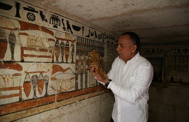 Mostafa Waziri, secretary-general of the Supreme Council of Antiquities, displays a small statue at a recently discovered tomb at the Saqqara area, in Giza, Egypt, on March 19, 2022. (Reuters)