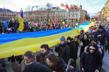 People walk with a giant many meter-long Ukrainian flag to protest against the Russian invasion of Ukraine during a celebration of Lithuania's independence in Vilnius, Lithuania, on March 11, 2022. (AFP)