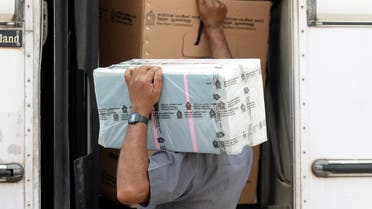 An electoral official collects ballot papers and boxes from a distribution center to be brought to polling stations on the eve of the parliamentary elections in Colombo on August 4, 2020. (AFP)
