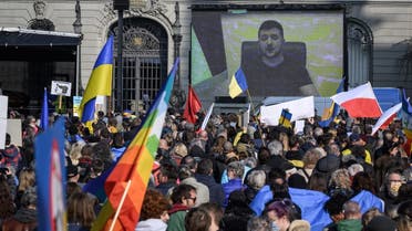 Ukrainian President Volodymyr Zelenskyy is displayed on a giant screen after delivering a live voice message during a demonstration against the Russian invasion of Ukraine in front of the Swiss House of Parliament in Bern, on March 19, 2022. (AFP)