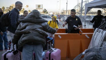 A Customs and Border Protection agent asks for documents to a Ukrainian family seeking for asylum before letting them in at the San Ysidro Crossing port in Tijuana, Baja California state, Mexico, on March 17, 2022. (AFP)