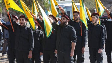 Hezbollah fighters raise party flags during an event to commemorate a suicide attack against Israeli forces in southern Lebanon. (File Photo: AFP)