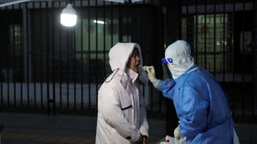 A medical worker takes a swab sample from a resident at a makeshift nucleic acid testing site during a mass testing for the coronavirus disease (COVID-19), near a residential compound in Beijing. China March 20, 2022. (File photo: Reuters)