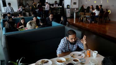 Employees eat their meals during a lunch break at an office pantry in Gurugram, India, on February 25, 2022. (Reuters)