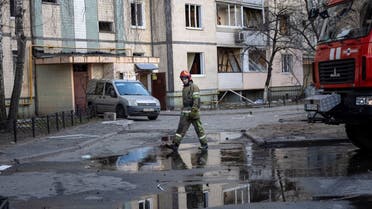 A firefighter walks near a residential building which was hit by the debris from a downed rocket, in Kyiv, on March 20, 2022, as Russian forces try to encircle the Ukranian capital. (AFP)