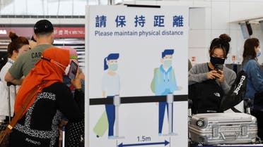 Travelers wearing face masks queue at the check-in counters of the Hong Kong International Airport amid the coronavirus pandemic in Hong Kong, China, on March 21, 2022. (Reuters)