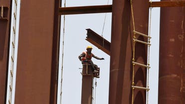 A labourer sits atop a steel girder at the construction site of a hospital building in Ahmedabad, India, May 6, 2015. REUTERS/