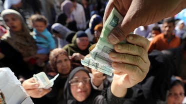 مواطنون مصريون يشترون سلعاً أساسية مدعومة من الحكومة (رويترز)
